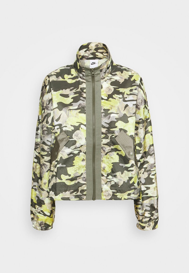 Chaqueta de camuflaje en verde, amarillo y gris. Cuenta con un alto cuello, cremallera frontal y dos bolsillos laterales con solapas. Textura de tela suave.