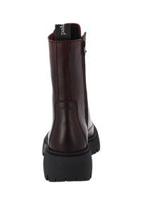 Botín de piel burdeos con suela de goma negra gruesa, cremallera lateral y cuello acolchado para mayor comodidad. Textura suave, costuras mínimas.
