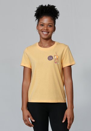 Gelbes Baumwoll-T-Shirt mit Rundhalsausschnitt, kurzen Ärmeln und einer verspielten Grafik mit einer Katze in einem Glas auf der Vorderseite.