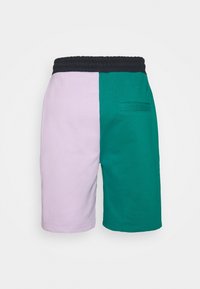 Cotton shorts featuring a split design: one side is light purple, the other dark green. Elastic waistband and back pocket detail.