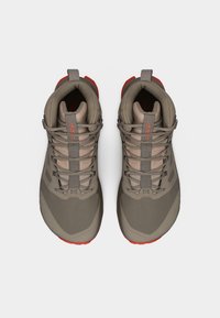 Ζευγάρι γκρι και κόκκινα ψηλά ορειβατικά παπούτσια με κορδόνια, σε θέα από πάνω σε λευκό φόντο.