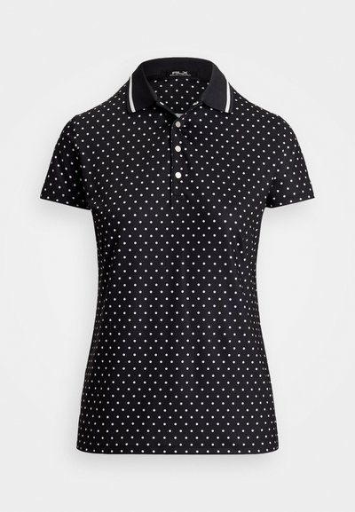 Melnā polo krekla ar baltām punktiņām, ar apkakles izgriezumu un svītrainām akcentiem, īsām piedurknēm un pogu aizdari.