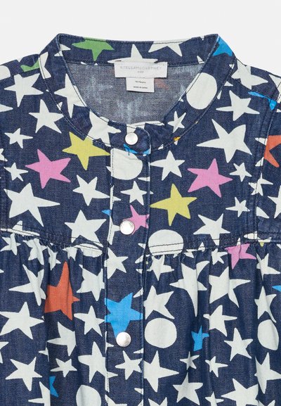 Τζιν φόρεμα με ναυτικό μπλε φόντο και πολύχρωμα μοτίβα αστεριών και κύκλων. Κλείσιμο με κουμπιά και σχεδίαση φούστας με πτυχώσεις.