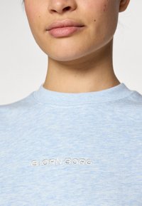 Light blue T-shirt made of soft fabric, featuring a crew neckline and a subtle, embroidered "BJÖRN BORG" logo on the front.