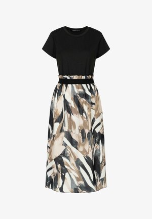 Top negro de manga corta con cintura elástica; la falda fluida presenta un patrón abstracto en tonos beige, negro y blanco.