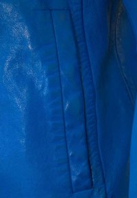 Blaue Lederjacke mit glatter Textur, vertikalen Nähten und einer Seitentasche. Die Farbe ist lebhaft und einheitlich mit einem eleganten Finish.