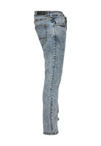 Jean en denim à lavage clair, avec une coupe ajustée, cinq poches, des surpiqûres contrastées et une texture légèrement délavée.