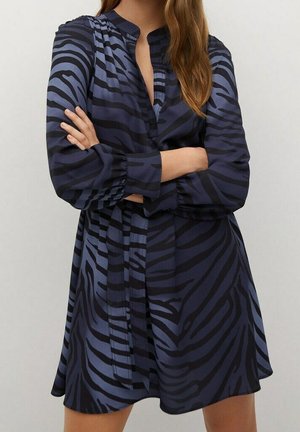 Vestido azul con un patrón de rayas de cebra, que presenta un cuello abotonado y mangas largas. Hecho de una tela suave, tiene un corte holgado y un cinturón de lazo.