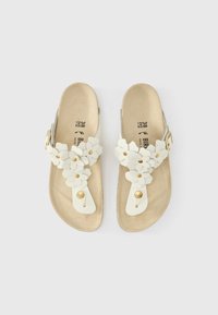 Λευκά σανδάλια με λουλουδένιες διακοσμήσεις, διαθέτουν επίπεδη σόλα και ρυθμιζόμενο πόρπη. Μαλακό υλικό και υφασμένη πατούσα με χρυσές λεπτομέρειες.