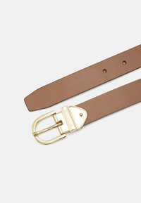 Cintura in pelle marrone con una fibbia in metallo dorato. Presenta una texture liscia e più fori per la regolazione. Il logo è visibile sulla fibbia.