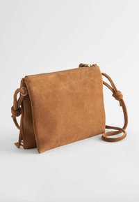 Borsa a tracolla in suede marrone con chiusura a zip, forma rettangolare, dettaglio della tracolla annodata e superficie liscia.