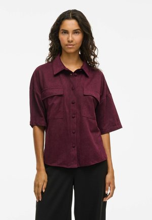 Burgunderfarget kortermet skjorte i mykt stoff, med krage, knappelukking foran og to brystlommer med avslappet passform.