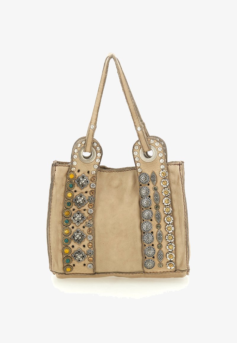 Borsa a mano in pelle beige con due manici, caratterizzata da borchie decorative e ornamenti metallici su entrambi i lati. Texture liscia.