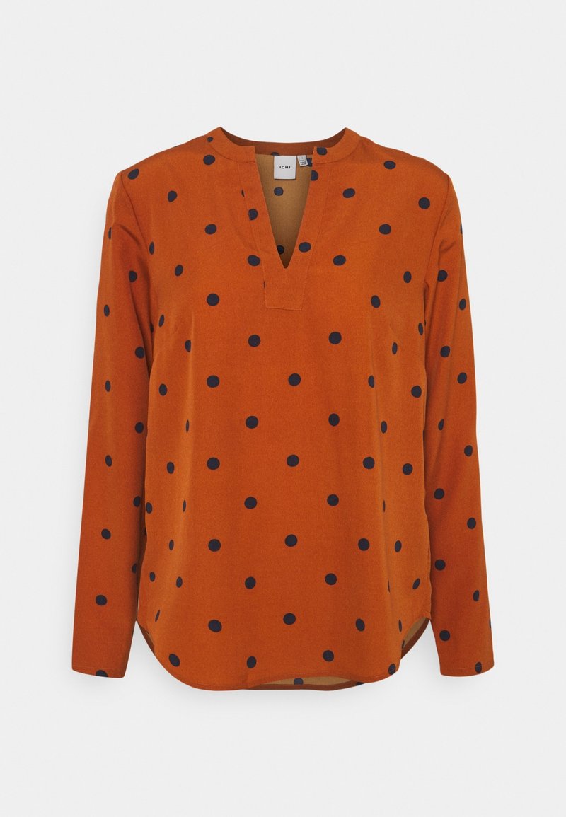 Blouse orange à manches longues avec pois bleu marine, encolure en V, coupe décontractée et ourlet légèrement arrondi. Tissu lisse avec une texture douce.