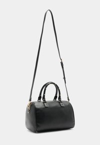 Schwarze Leder-Handtasche mit goldfarbener Hardware, ovaler Form, doppelten Griffen und einem abnehmbaren Schulterriemen. Strukturierte Oberfläche mit Nietenakzenten.