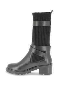 Bota negra hasta la rodilla con sección inferior de cuero, parte superior de tela acanalada y doble correa negra. Suela de goma para agarre y estabilidad.