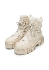 Beżowe botki na sznurowadła z teksturowaną górą z sztucznego futra, wyściełanym kołnierzem i masywną, karbowaną podeszwą. Posiadają złote akcenty w postaci okucia.