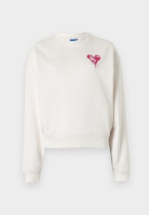 Biała skrócona bluza z miękkiego materiału, z różowym sercem ociekającym na piersi oraz ściągaczami na rękawach.