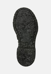 Svart skosula med texturerade mönster, med en rektangulär Camper-logotyp och storlek 38-emblem. Bakgrunden är helt vit.