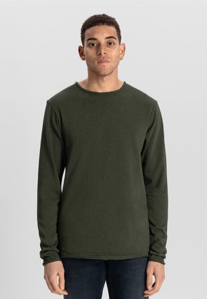 Grøn langærmet t-shirt i et blødt, tekstureret stof med rund hals og afslappet pasform. Søm detaljer tilføjer subtil interesse.