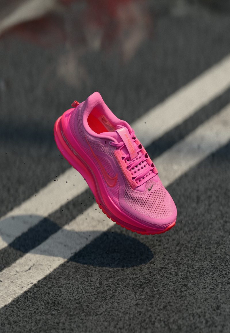 Helle pinke Sportschuhe mit Mesh-Obermaterial, gepolstertem Kragen und Gummisohle. Verfügt über kontrastierende Akzente und ein strukturiertes Design.