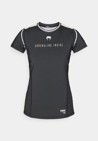 Μαύρο αθλητικό κοντομάνικο πουκάμισο από ελαφρύ ύφασμα. Διαθέτει το κείμενο «ADRENALINE INSIDE», αντιθετικές λεπτομέρειες στους ώμους και διακριτικό λογότυπο.