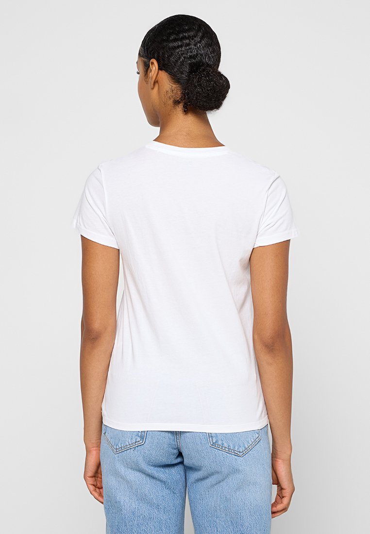 Camiseta de algodón blanca con mangas cortas, cuello redondo y una forma ajustada. La parte posterior presenta un diseño liso, sin logotipos ni patrones visibles.