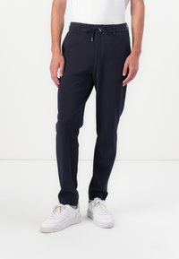 Marine joggers gemaakt van zacht materiaal, met een elastische tailleband en een trekkoord, zijzakken en taps toelopende pijpen.