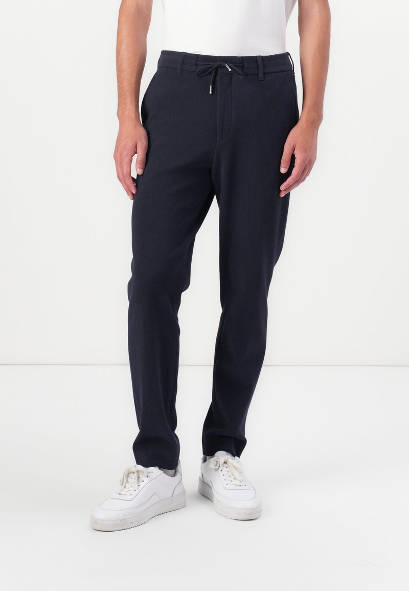 Marine joggers gemaakt van zacht materiaal, met een elastische tailleband en een trekkoord, zijzakken en taps toelopende pijpen.