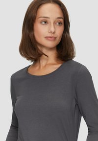 Lange mouwen, ronde hals top in donkergrijs, gemaakt van een gladde, lichte stof met minimale naden, die een slanke en understated uitstraling biedt.