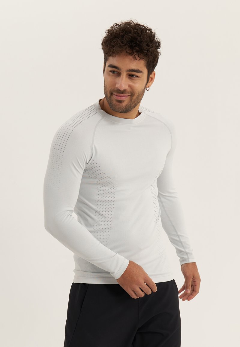 Helles graues langärmeliges Sportshirt aus glattem Stoff, mit strukturierten Punktmustern an den Schultern und Seiten, runder Ausschnitt.