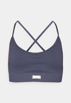 Donkergrijze sportbeha met geribbelde textuur. Heeft kruislings gespen en een klein logo-etiket op de voorrand.