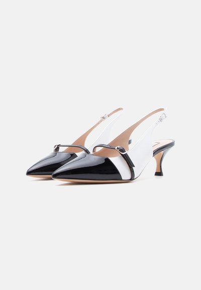 Μαύρα και λευκά slingback ψηλοτάκουνα από βινύλιο με μυτερές μύτες, μικρά τακούνια στιλέτο και ρυθμιζόμενα πλαϊνά λουριά.