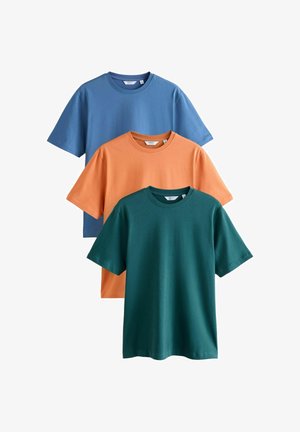 Tričko s okrúhlym výstrihom v modrej, oranžovej a tmavo zelenej farbe, zložené a usporiadané v vertikálnom prekrývajúcom sa rozložení na bielom pozadí.