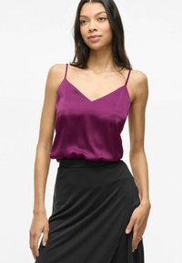 Satinė slyvų spalvos naktinukė su plonomis petnešomis ir V formos iškirpte, derinama su juoda apykakle suknele. Lygus paviršius ir laisvas siluetas.