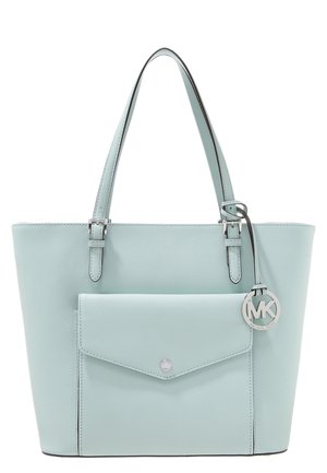 Sac cabas en cuir bleu clair avec deux anses d'épaule, poche avant avec rabat et breloque ronde argentée avec le logo Michael Kors.