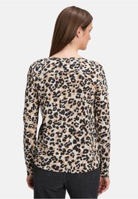 Langärmliges Oberteil mit Leopardenmuster in Beige und Schwarz, mit Rundhalsausschnitt und lockerer Passform, aus weichem, leichtem Stoff.