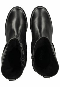 Botas negras de piel hasta el tobillo con un acabado suave, que cuentan con cremalleras laterales y punteras redondeadas. En el interior se muestra el logo y un suave revestimiento.