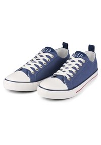 Zapatillas de lona azules con cordones y punteras blancas. Presentan un logo en la lengüeta y un borde de suela a rayas rojas y blancas. Suela de goma.