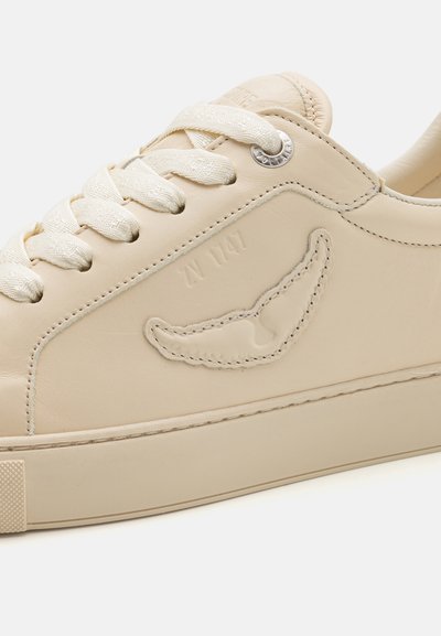 Sneaker in pelle color crema con superficie testurizzata, lacci piatti, logo impresso e suola spessa e testurizzata per una migliore aderenza.