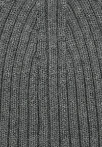 Szary dziany beanie z wypukłym wzorem prążków, wykonany z teksturowanej włóczki. Projekt charakteryzuje się pionowymi liniami oraz miękkim, przytulnym wyglądem.