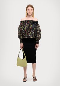 Μαύρη φλοράλ μπλούζα με γυμνούς ώμους και φουσκωτά μανίκια, συνδυασμένη με μια στενή μαύρη φούστα και μια τσάντα lime green. Μαύρα σανδάλια με λουράκια.