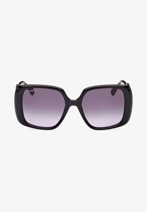 Gafas de sol negras de gran tamaño con un marco de plástico suave, lentes púrpuras en degradado y una forma cuadrada distintiva; presenta un logo en el lente izquierdo.
