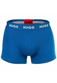 Blaue Baumwollboxershorts mit einem kontrastierenden weißen "HUGO"-Logo-Bund und einem roten Etikett. Glatte Textur, taillierte Passform und mittellange Schnittführung.