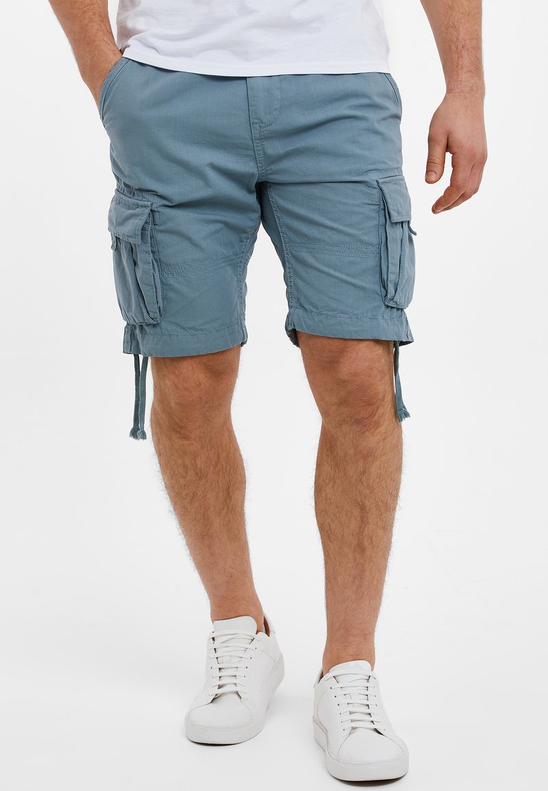 Pantaloni cargo blu chiaro realizzati in tessuto morbido, con molteplici tasche laterali, coulisse regolabile all'orlo e vestibilità rilassata.