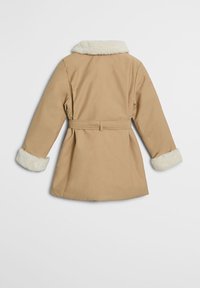 Beige Mantel mit einem sanften weißen Kunstfellkragen und -manschetten, tailliertem Gürtel und einer maßgeschneiderten Form. Die Rückseite zeichnet sich durch ein glattes, sauberes Design aus.