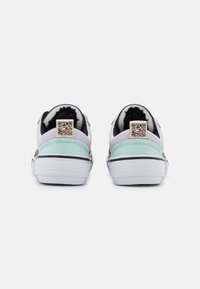 Sneakers z białą podeszwą, pastelowo fioletowym i miętowym wierzchem, czarną onowką i metką z kodem QR na pięcie. Zaprojektowane do noszenia na co dzień.