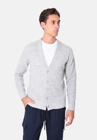 Cardigan grigio chiaro lavorato a maglia con scollo a V, maniche lunghe e cinque bottoni sulla parte anteriore. Presenta una texture a coste e un design semplice.