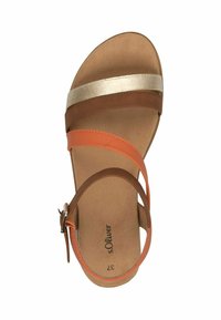 Bruine en oranje sandaal met een gouden metallic band, platte zool, enkelgesp en een textuur voetbed, met minimalistische designelementen.