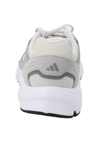 Scarpa sportiva grigia con tomaia in mesh, accenti in suede e colletto imbottito. Logo distintivo a tre righe sul tallone. Suola intermedia bianca.